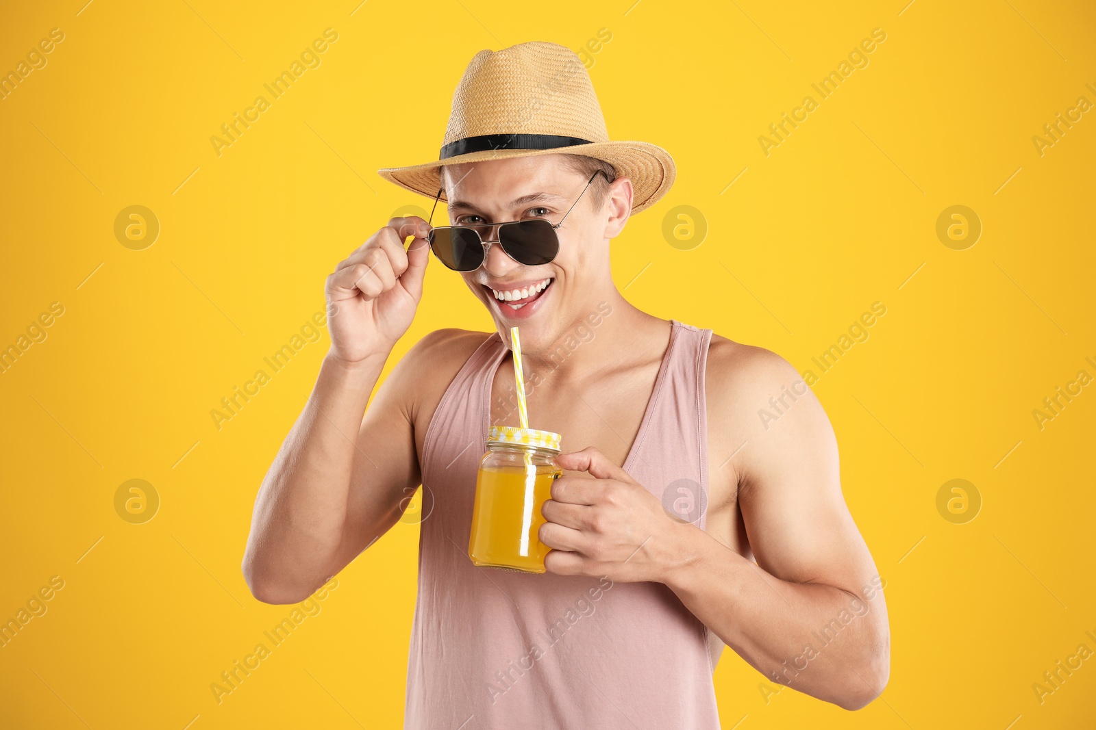 Photo of Man with juice and drinking straw on orange background