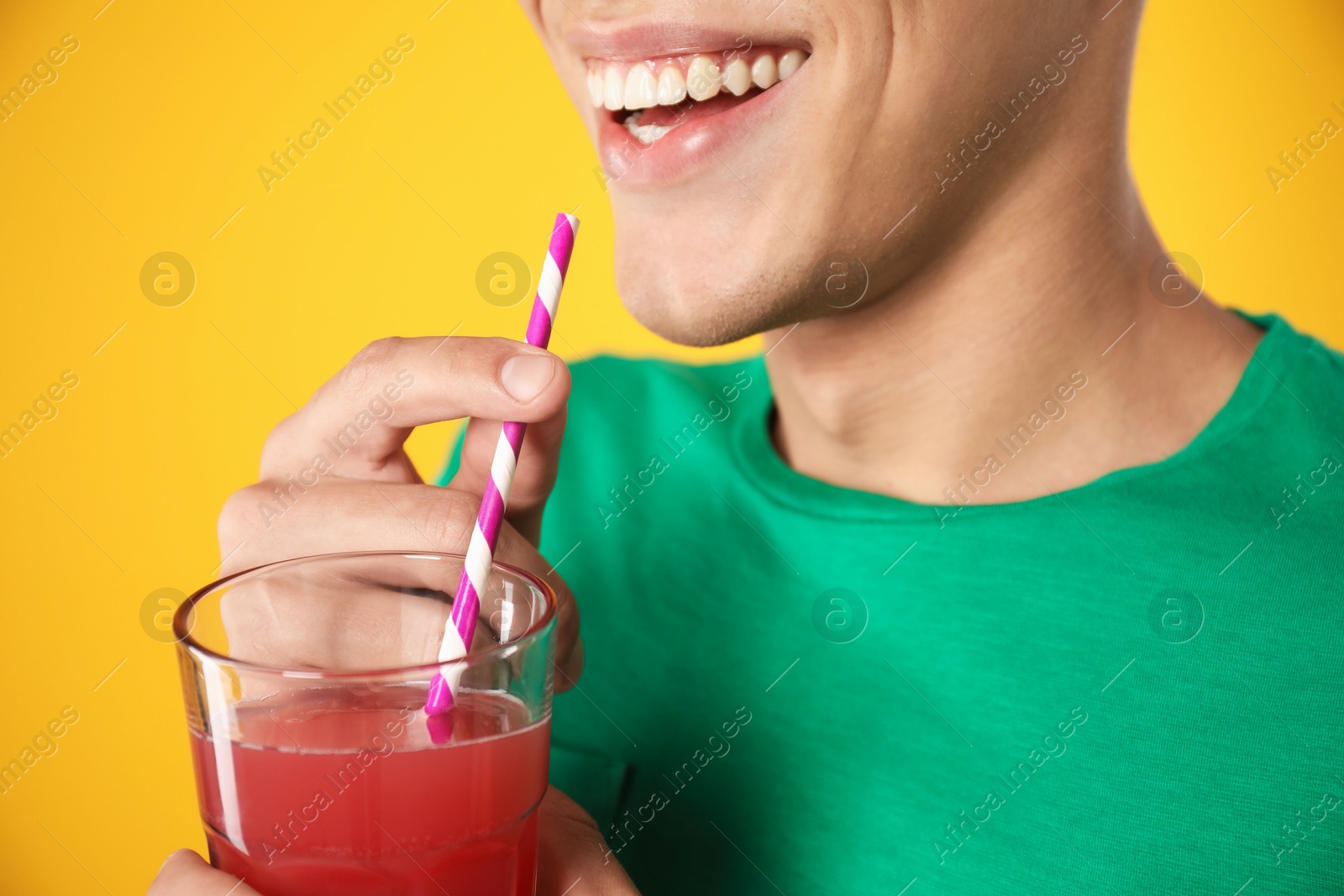 Photo of Man with juice and drinking straw on orange background, closeup