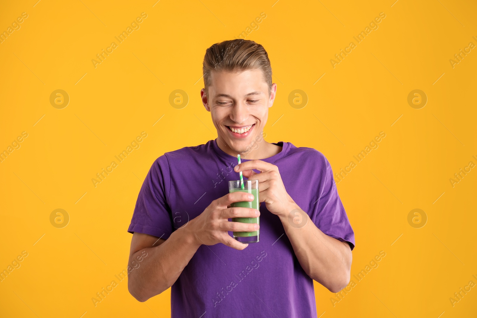 Photo of Man with juice and drinking straw on orange background