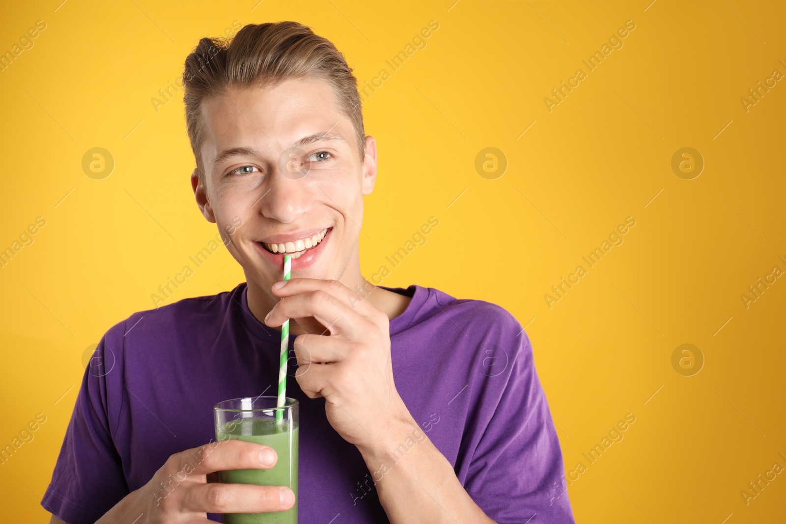 Photo of Man drinking juice through straw on orange background, space for text