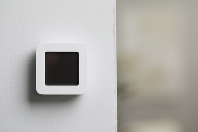 Photo of One thermostat on white wall indoors, space for text. Smart home system