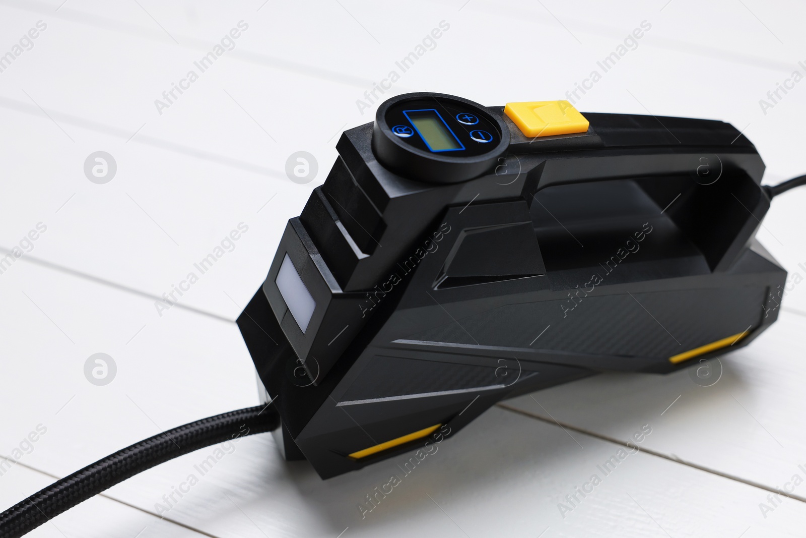 One black tire inflator on light wooden table, closeup Photo of One black tire inflator on light wooden table, closeup