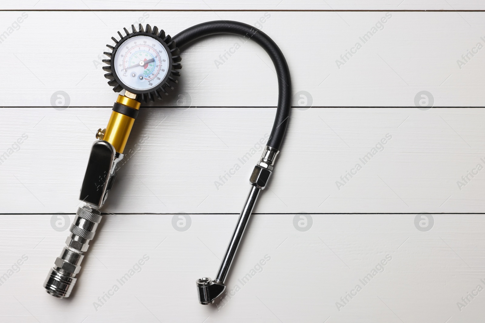 One tire inflation gun with gauge on light grey wooden table, top view Photo of One tire inflation gun with gauge on light grey wooden table, top view
