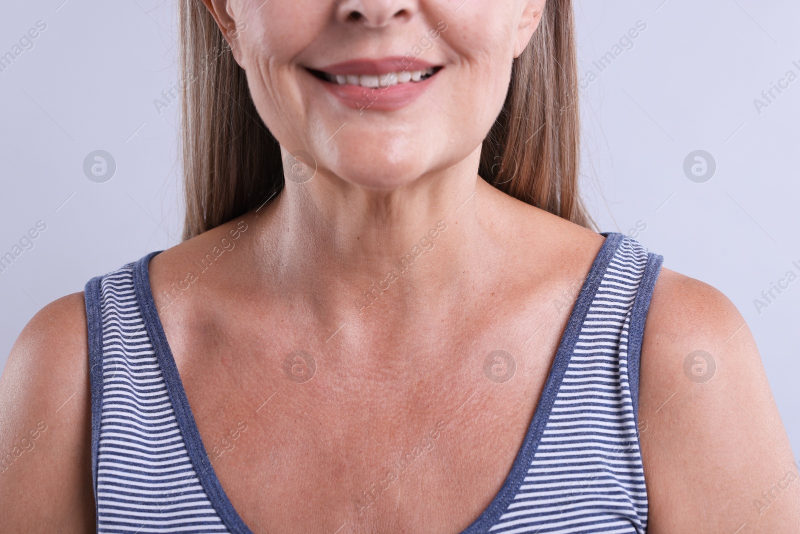 Smiling woman with healthy skin on light background, closeup Photo of Smiling woman with healthy skin on light background, closeup