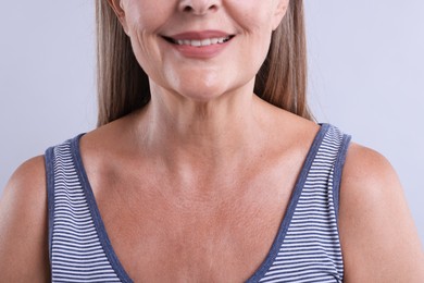 Photo of Smiling woman with healthy skin on light background, closeup