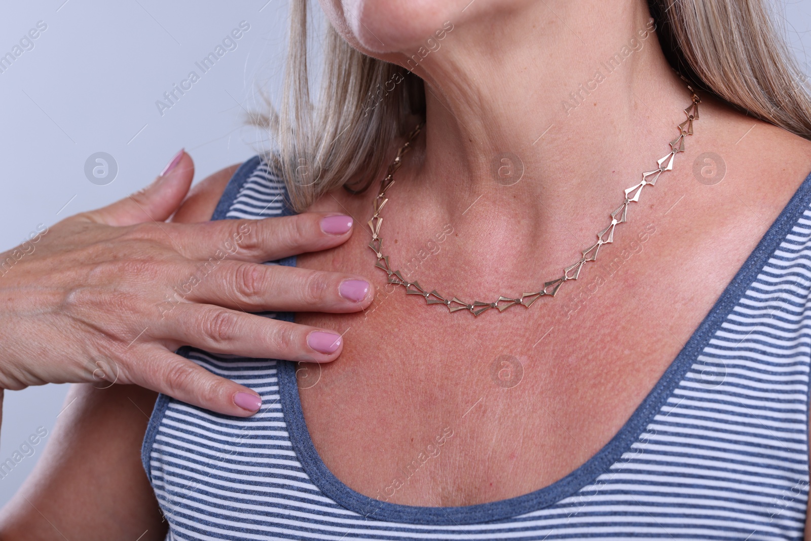 Woman wearing stylish necklace on light background, closeup Photo of Woman wearing stylish necklace on light background, closeup