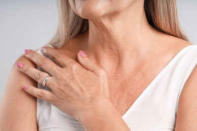 Photo of Woman wearing stylish ring on light background, closeup