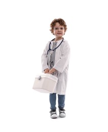 Photo of Choice of profession. Little boy with stethoscope and first aid kit pretending to be doctor on white background
