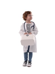 Photo of Choice of profession. Little boy with stethoscope and first aid kit pretending to be doctor on white background