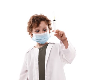 Photo of Choice of profession. Little boy in medical mask with syringe pretending to be doctor on white background