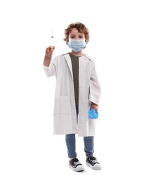 Photo of Choice of profession. Little boy in medical mask with syringe and glove pretending to be doctor on white background