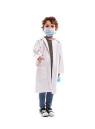 Photo of Choice of profession. Little boy in medical mask with syringe and glove pretending to be doctor on white background