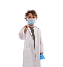 Photo of Choice of profession. Little boy in medical mask with syringe and glove pretending to be doctor on white background