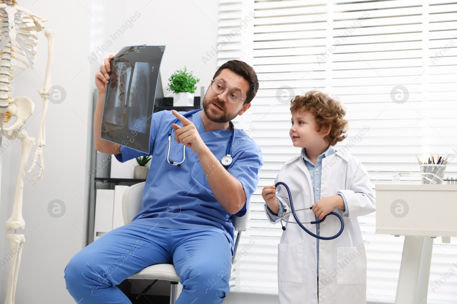 Choice of profession. Father and his son examining X-ray picture in clinic Photo of Choice of profession. Father and his son examining X-ray picture in clinic