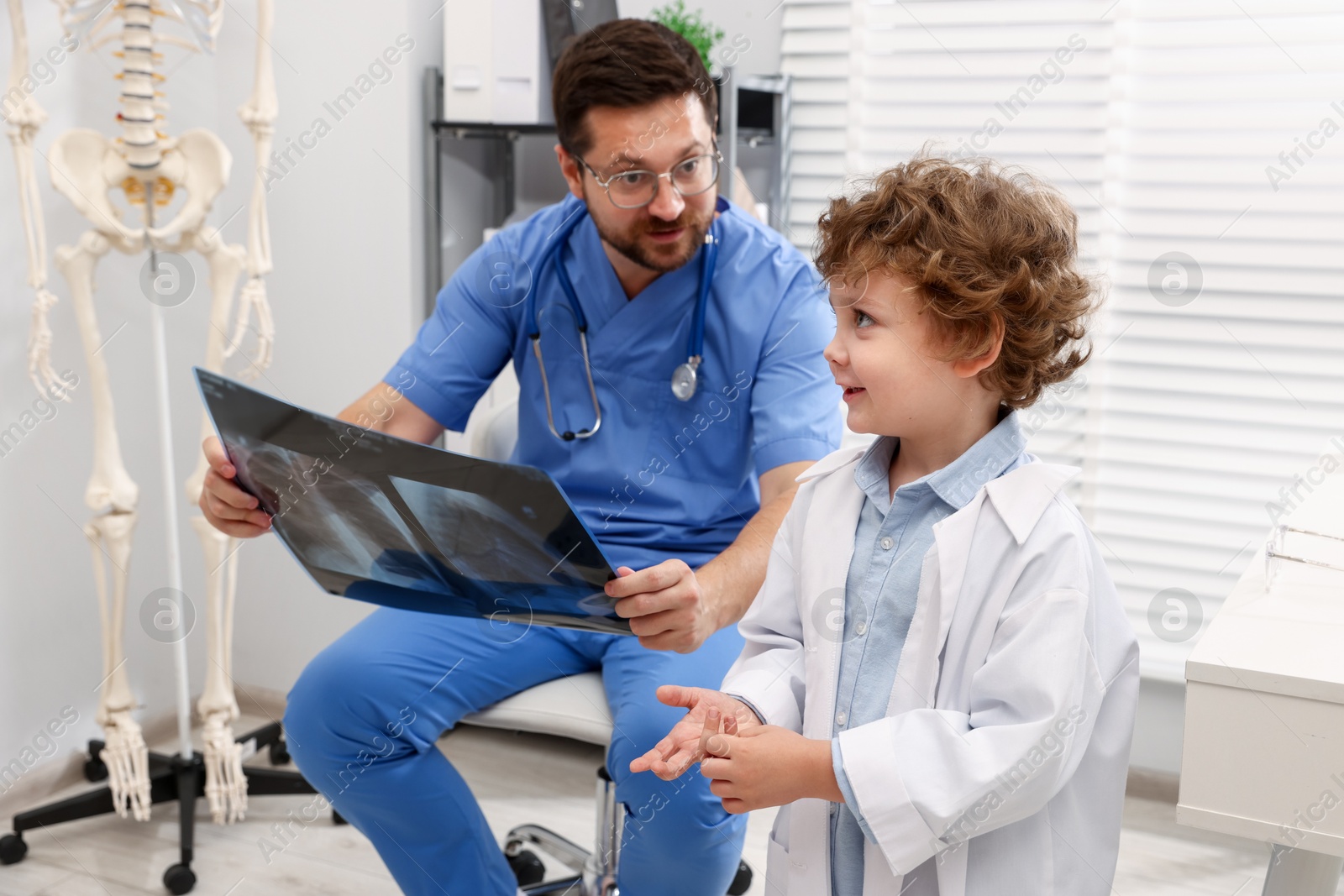 Choice of profession. Father and his son examining X-ray picture in clinic Photo of Choice of profession. Father and his son examining X-ray picture in clinic