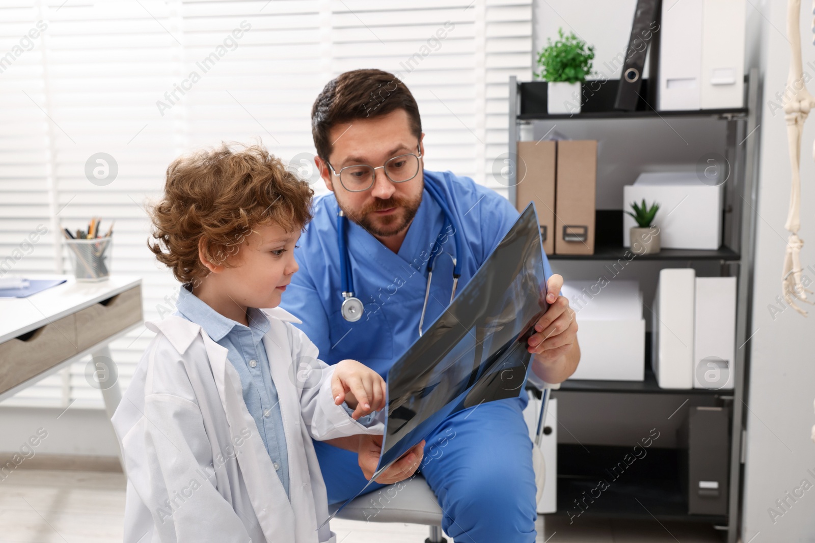 Choice of profession. Father and his son examining X-ray picture in clinic Photo of Choice of profession. Father and his son examining X-ray picture in clinic