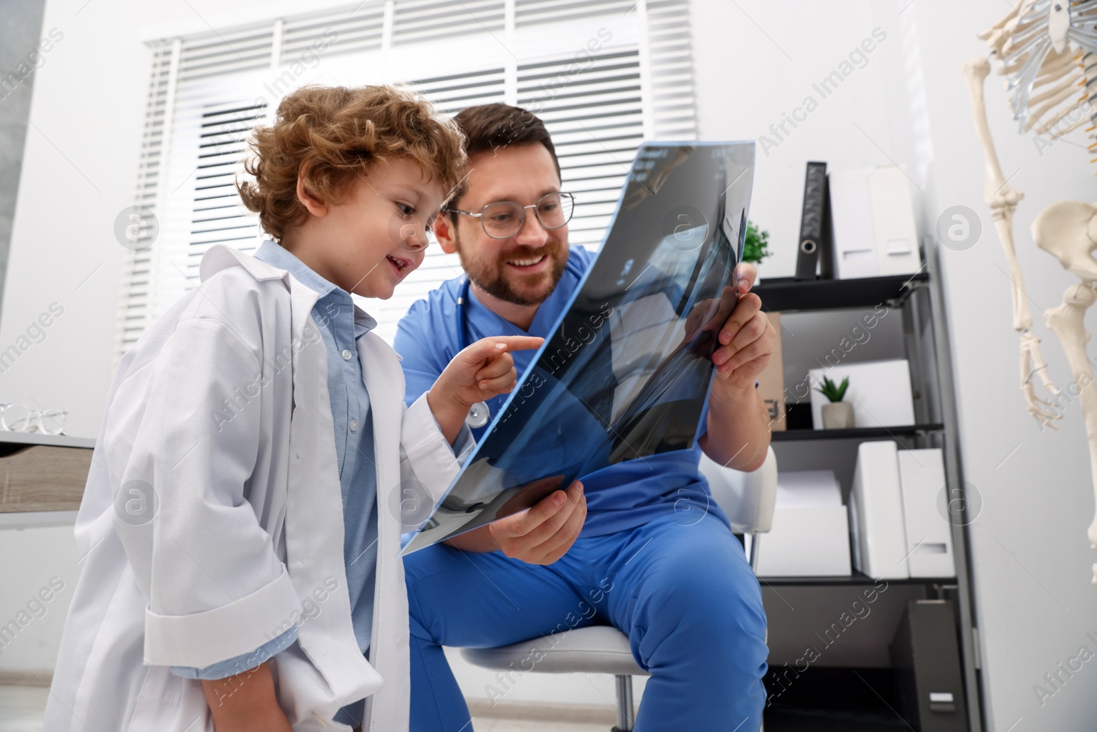 Choice of profession. Father and his son examining X-ray picture in clinic Photo of Choice of profession. Father and his son examining X-ray picture in clinic