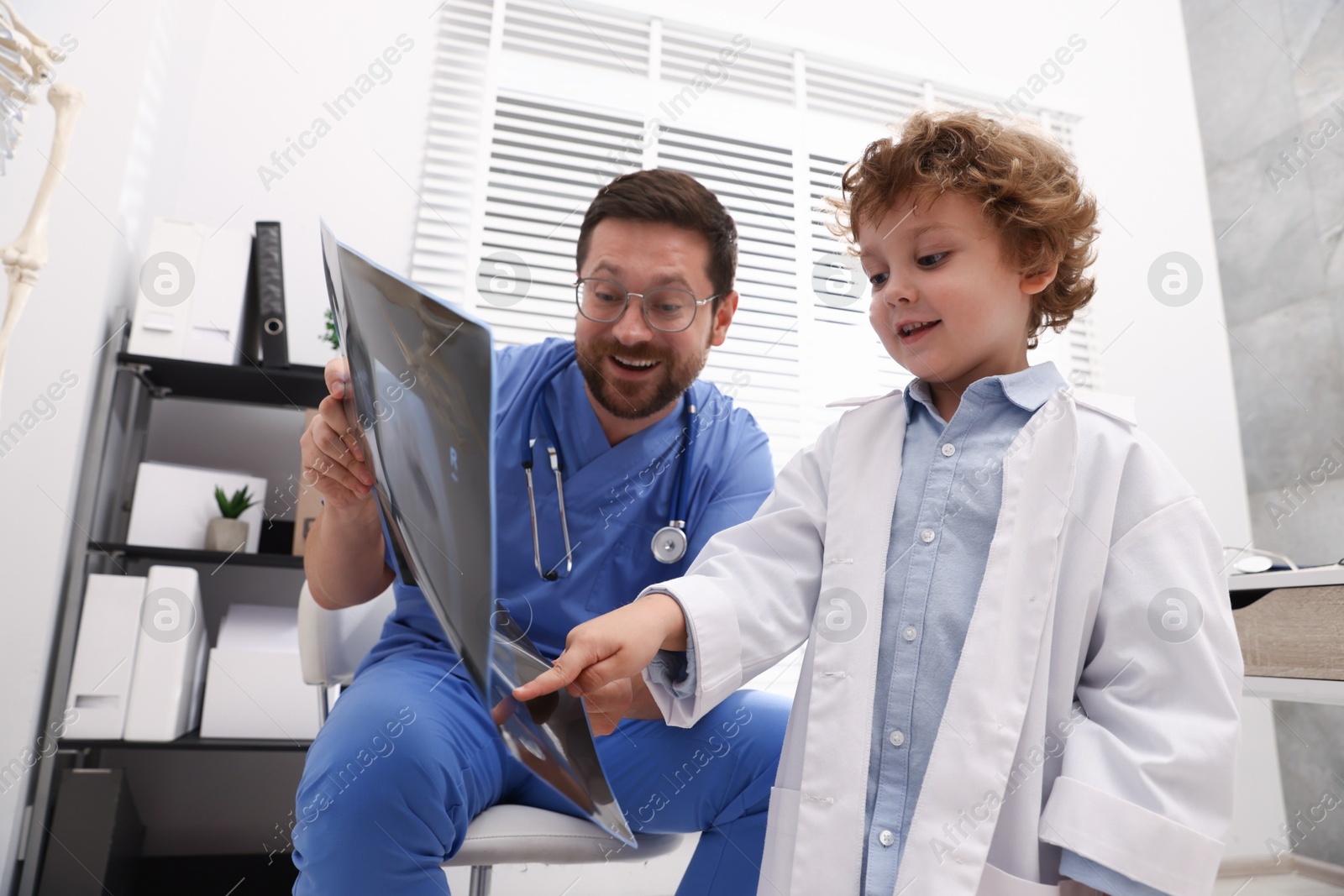 Choice of profession. Father and his son examining X-ray picture in clinic Photo of Choice of profession. Father and his son examining X-ray picture in clinic