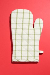 Photo of One oven glove on red background, top view