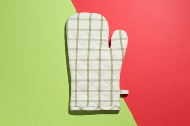 Photo of One oven glove on color background, top view