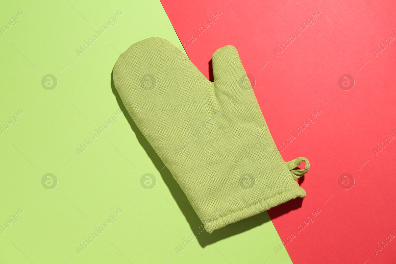 One oven glove on color background, top view Photo of One oven glove on color background, top view