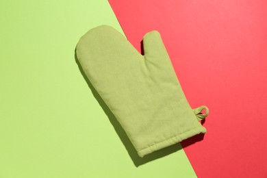 Photo of One oven glove on color background, top view