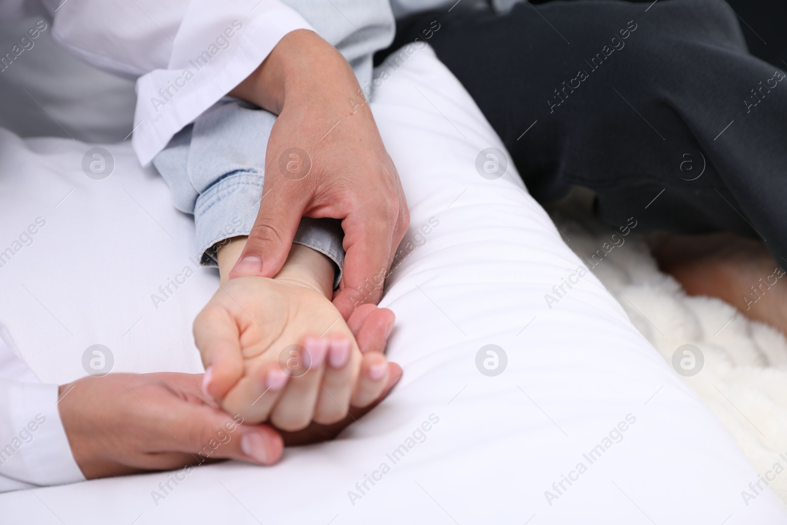 Doctor checking woman's pulse with fingers at home, closeup Photo of Doctor checking woman's pulse with fingers at home, closeup