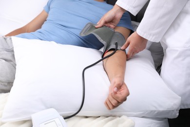 Photo of Doctor checking man's heart rate and blood pressure via sphygmomanometer at home, closeup