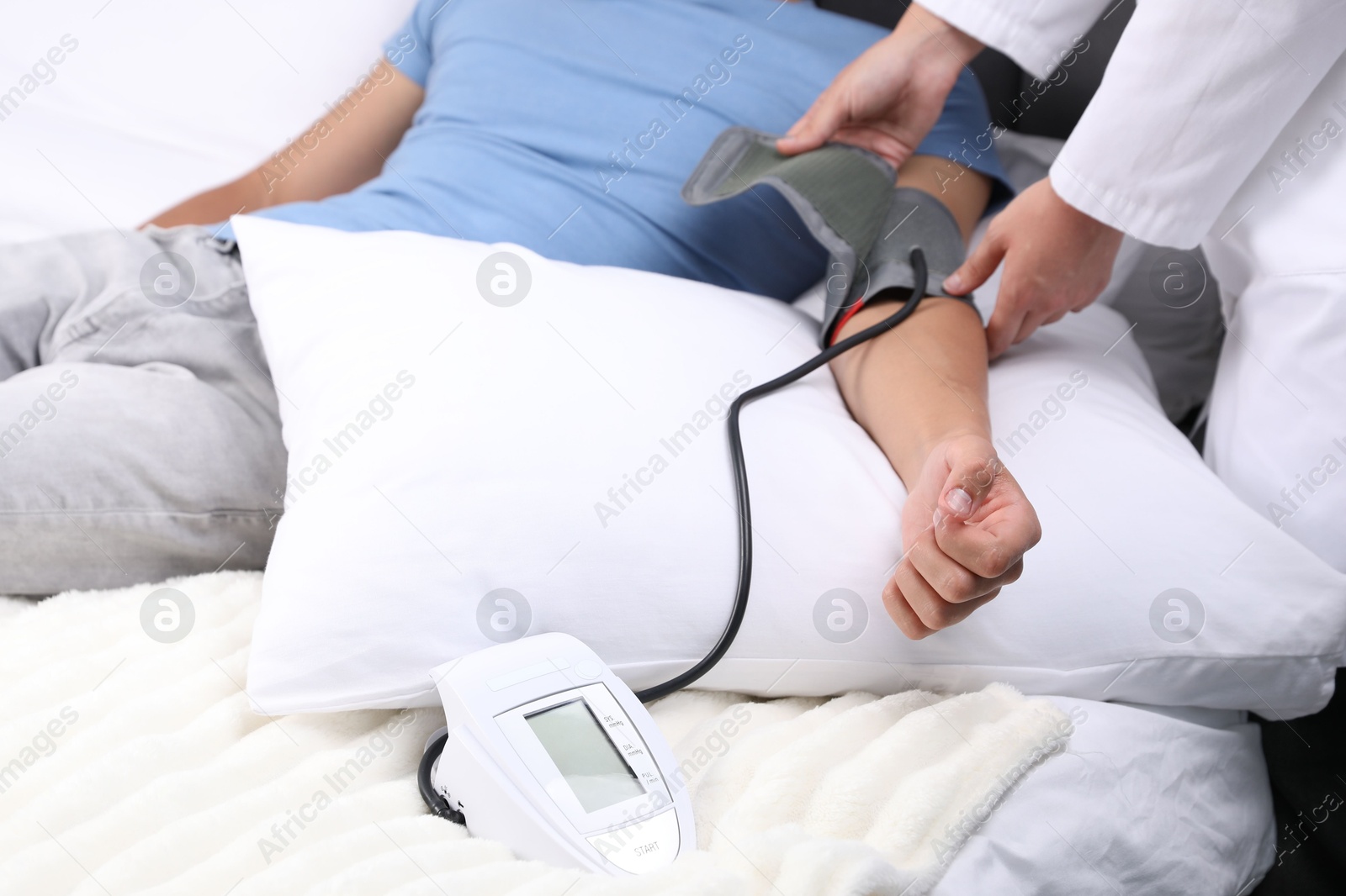 Doctor checking man's heart rate and blood pressure via sphygmomanometer at home, closeup Photo of Doctor checking man's heart rate and blood pressure via sphygmomanometer at home, closeup