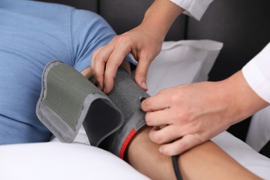 Photo of Doctor checking man's heart rate and blood pressure via sphygmomanometer at home, closeup