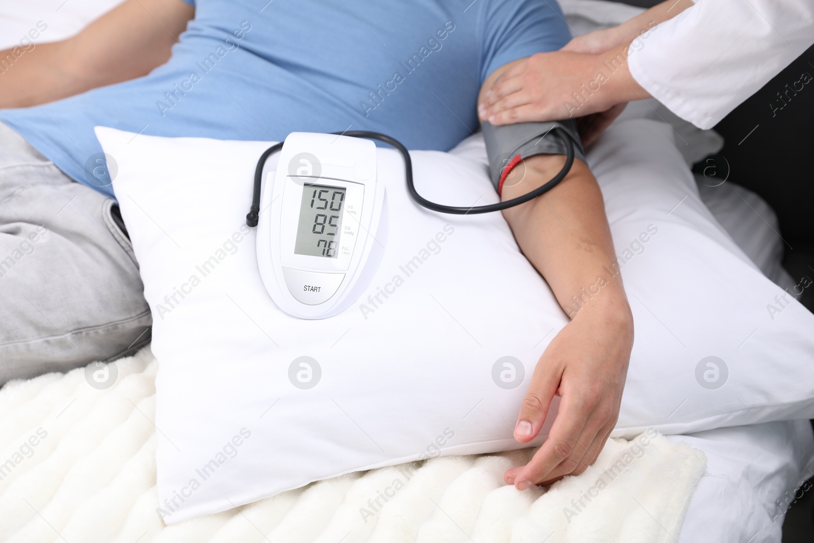 Doctor checking man's heart rate and blood pressure via sphygmomanometer at home, closeup Photo of Doctor checking man's heart rate and blood pressure via sphygmomanometer at home, closeup