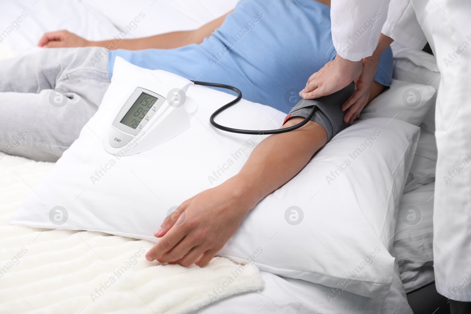 Doctor checking man's heart rate and blood pressure via sphygmomanometer at home, closeup Photo of Doctor checking man's heart rate and blood pressure via sphygmomanometer at home, closeup