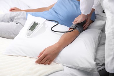 Photo of Doctor checking man's heart rate and blood pressure via sphygmomanometer at home, closeup