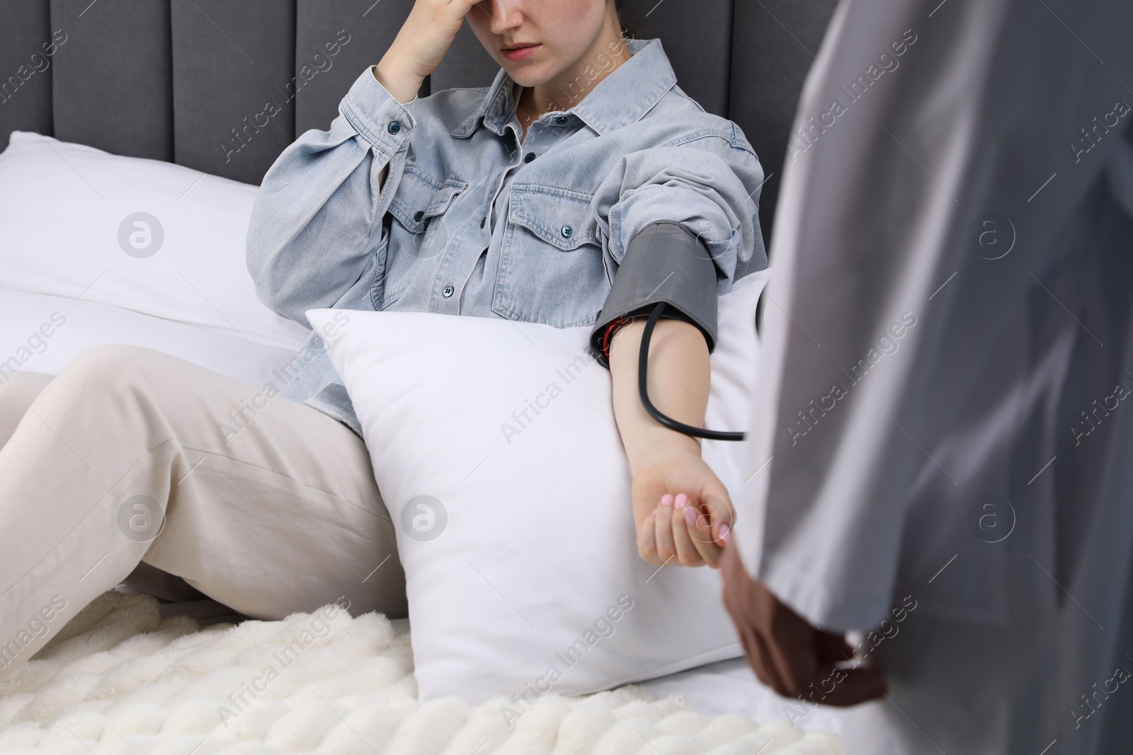 Doctor checking woman's heart rate and blood pressure via sphygmomanometer at home, closeup Photo of Doctor checking woman's heart rate and blood pressure via sphygmomanometer at home, closeup