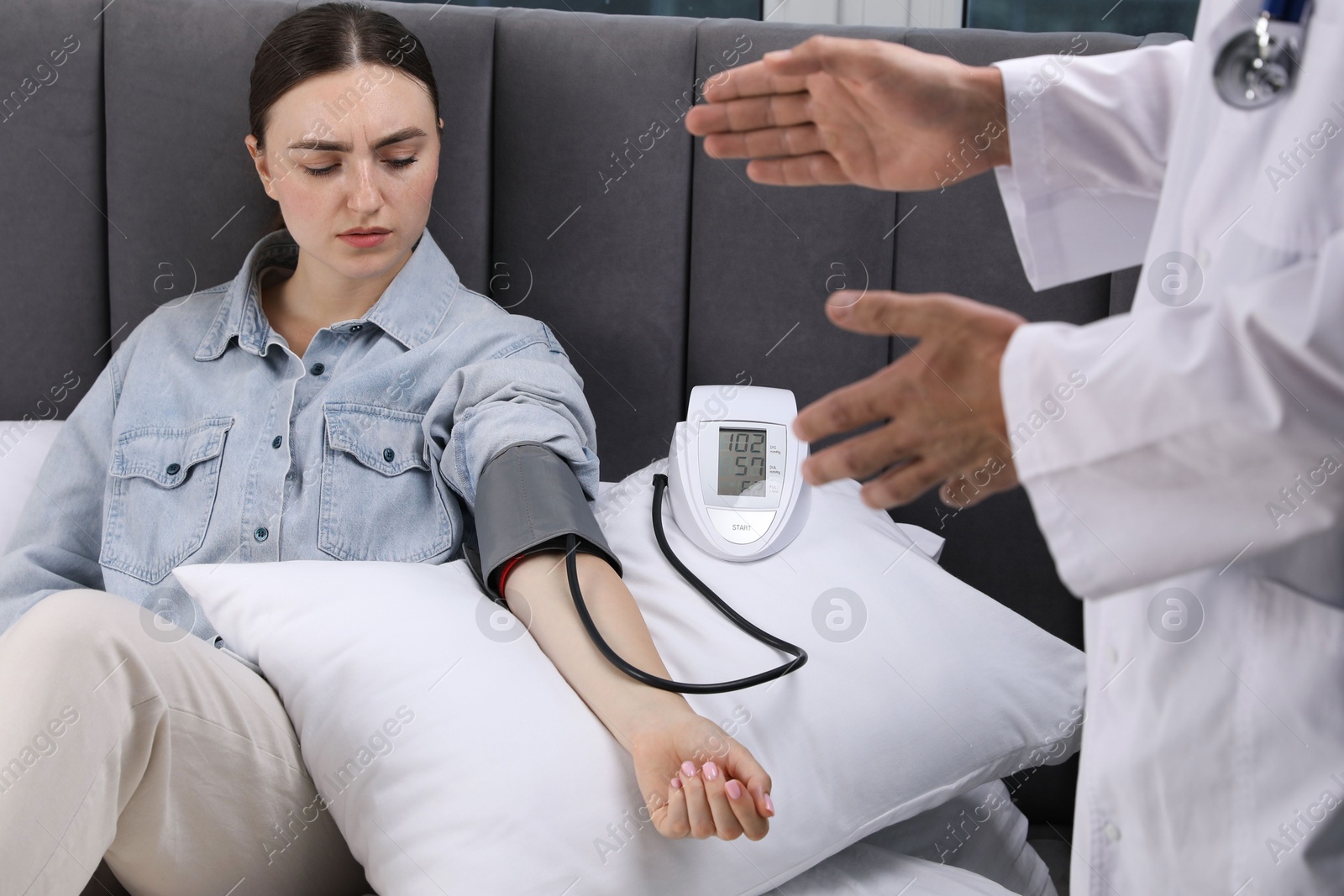 Doctor checking woman's heart rate and blood pressure via sphygmomanometer at home, closeup Photo of Doctor checking woman's heart rate and blood pressure via sphygmomanometer at home, closeup