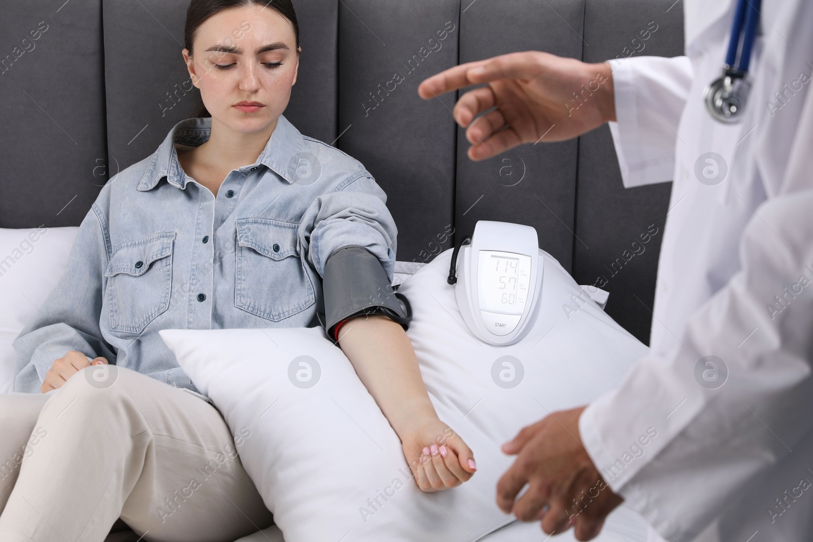 Doctor checking woman's heart rate and blood pressure via sphygmomanometer at home, closeup Photo of Doctor checking woman's heart rate and blood pressure via sphygmomanometer at home, closeup