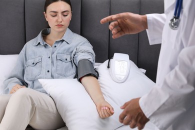 Photo of Doctor checking woman's heart rate and blood pressure via sphygmomanometer at home, closeup