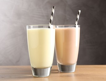 Photo of Tasty milkshakes in glasses on wooden table