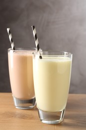 Photo of Tasty milkshakes in glasses on wooden table