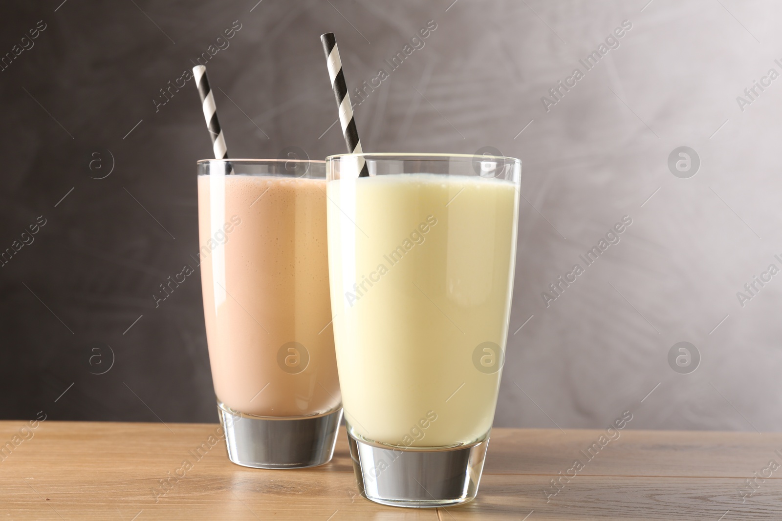 Photo of Tasty milkshakes in glasses on wooden table