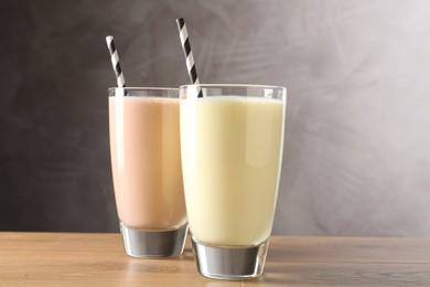 Photo of Tasty milkshakes in glasses on wooden table