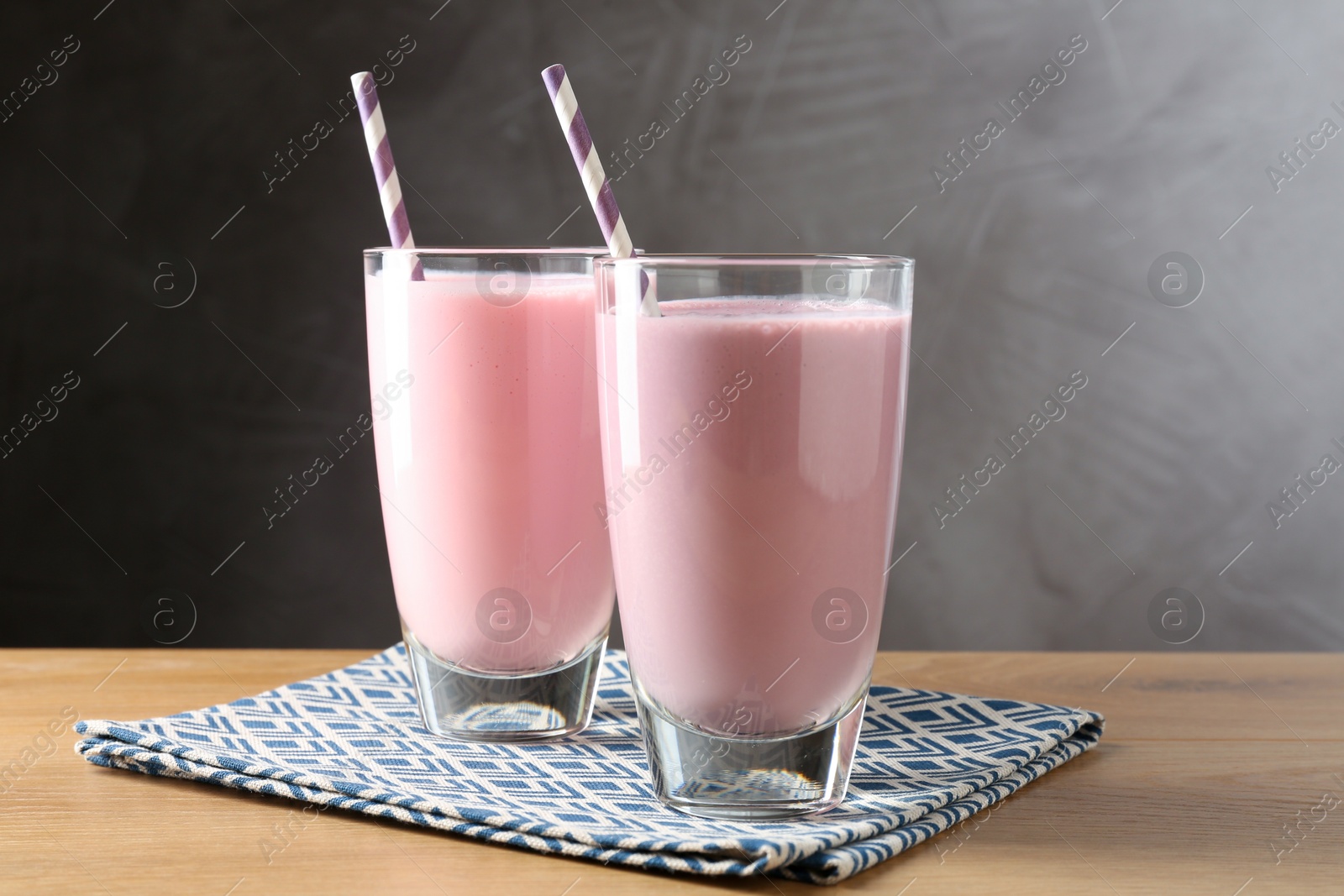 Photo of Tasty milkshakes in glasses on wooden table