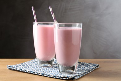 Photo of Tasty milkshakes in glasses on wooden table