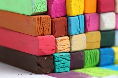 Photo of Many colorful chalk pastels on white background, closeup