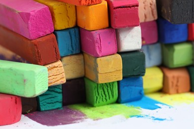 Photo of Many colorful chalk pastels on white background, closeup