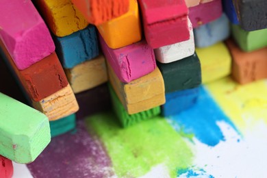 Photo of Many colorful chalk pastels on white background, closeup