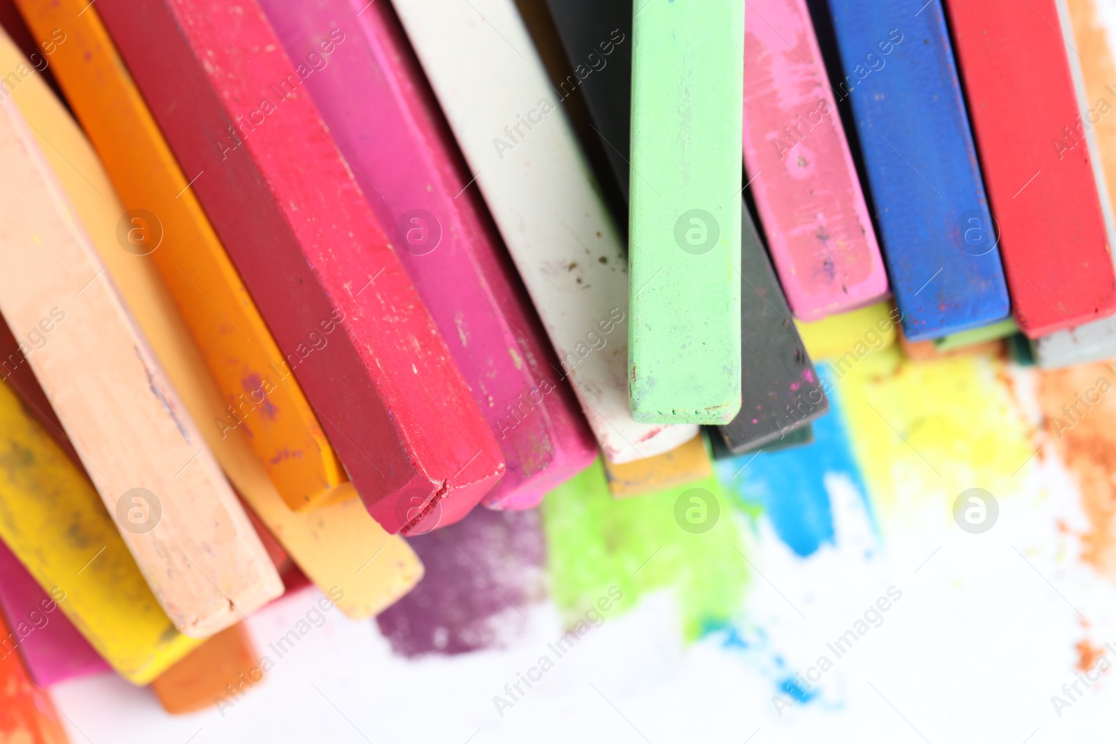 Photo of Many colorful chalk pastels on white background, closeup