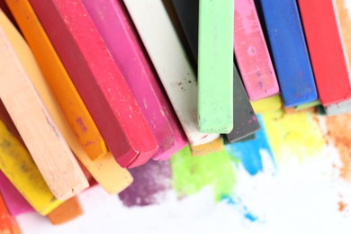 Photo of Many colorful chalk pastels on white background, closeup