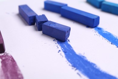 Photo of Colorful chalk pastels on white background, closeup