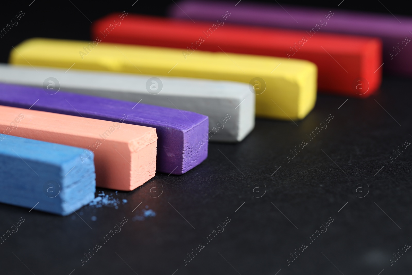 Colorful chalk pastels on black background, closeup Photo of Colorful chalk pastels on black background, closeup